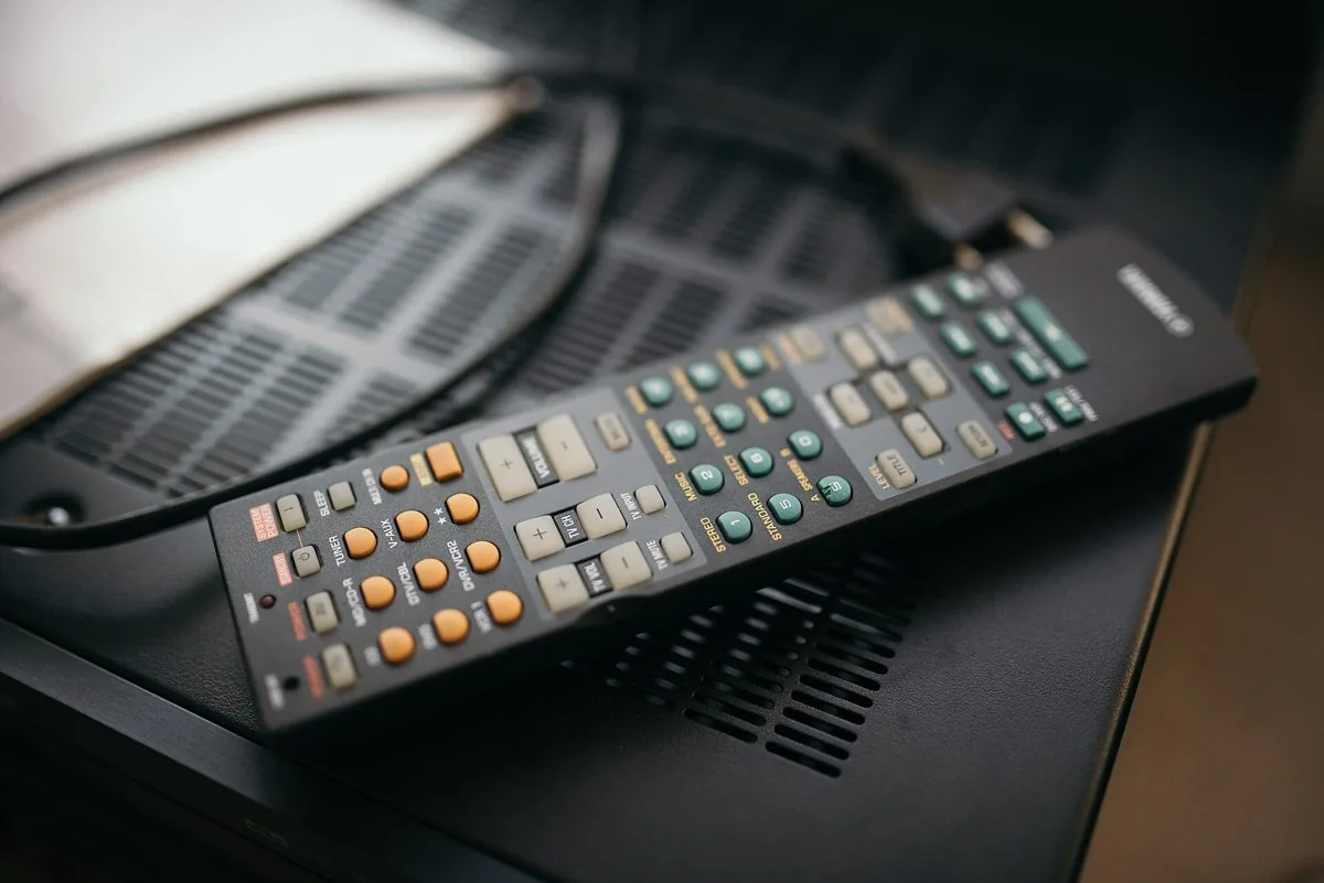 Sohva television edessä; ruudun vasen puolisko näyttää suoraa jalkapalloa ja oikea suoratoistokirjastoa elokuvajulisteineen
